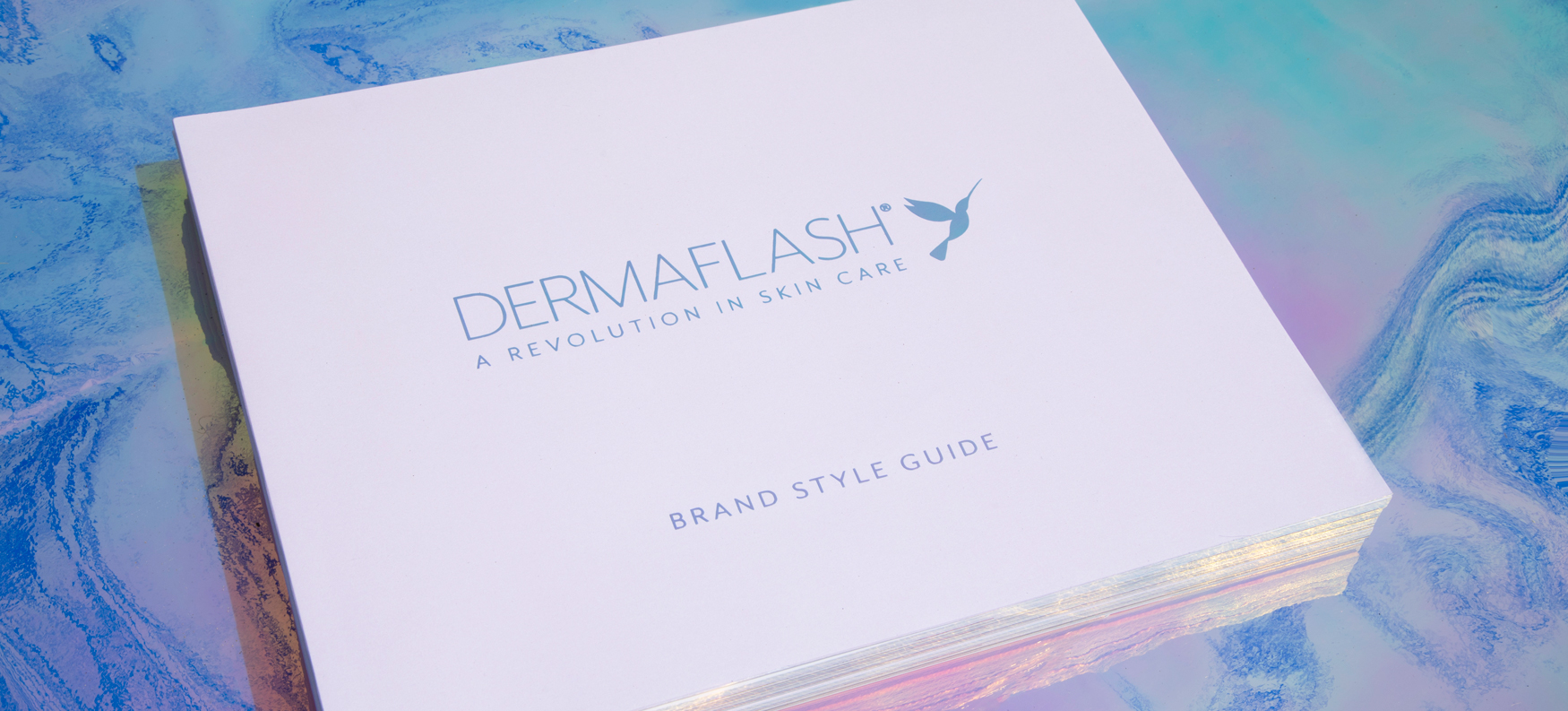 DERMAFLASH product and brand book styled together, representing the cohesive design and packaging created for the brand.